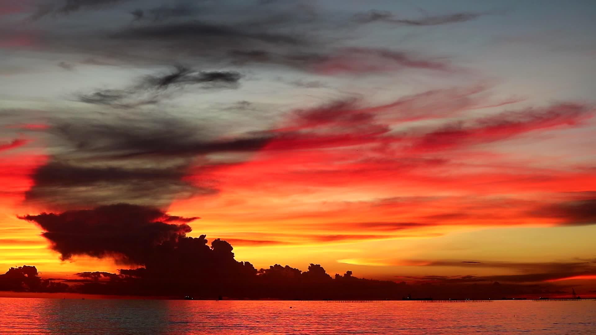 橙色天空的红色日落和大海的暗红云视频的预览图