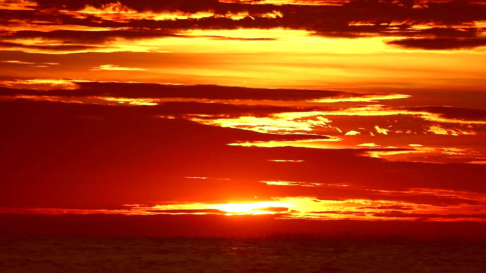 橙色天空的红色日落和海面的红色云彩视频的预览图
