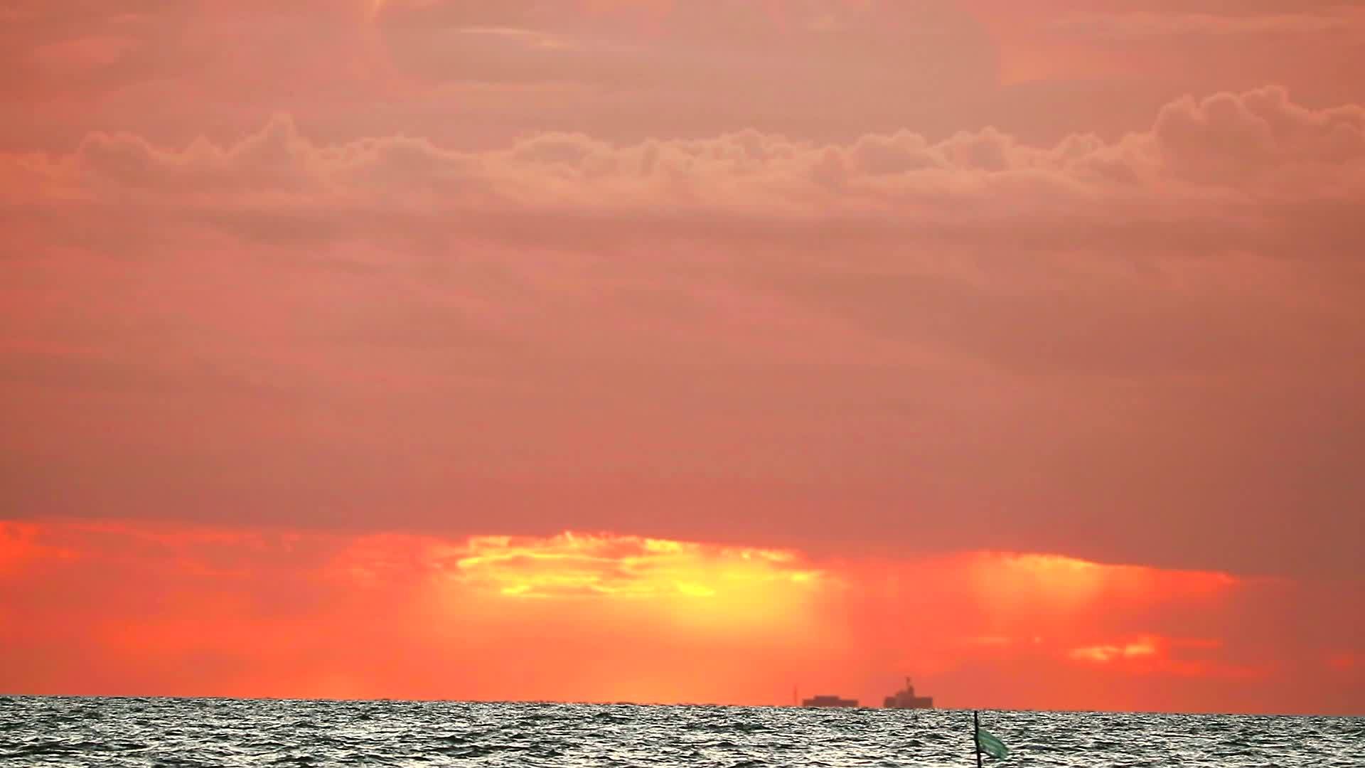 模糊的日落橙色的天空和红色的云在海上移动和波浪视频的预览图