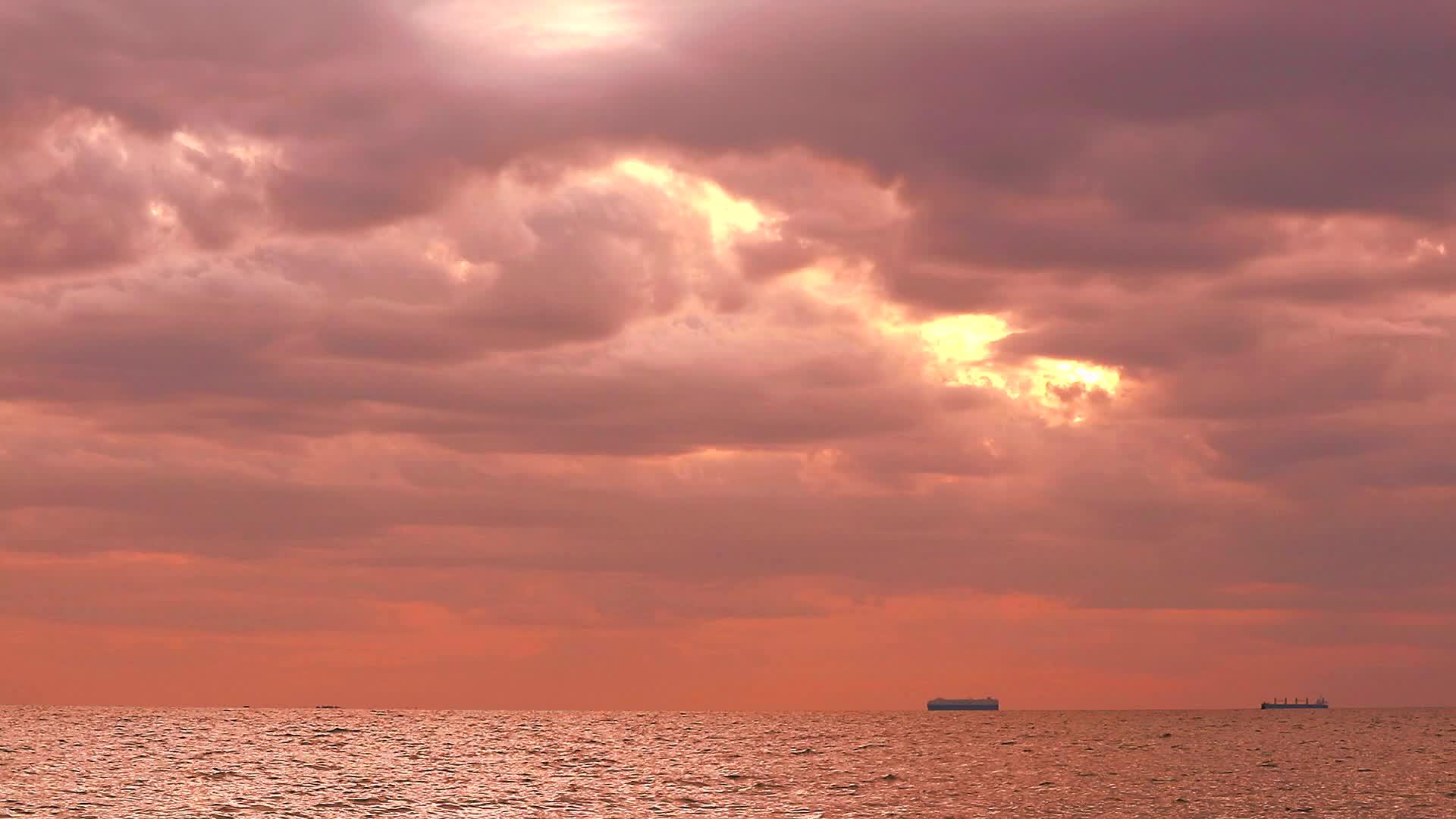 日落、黄色、橙色、黄色的天空、红色的风暴云在海上、货船和渔船上移动视频的预览图