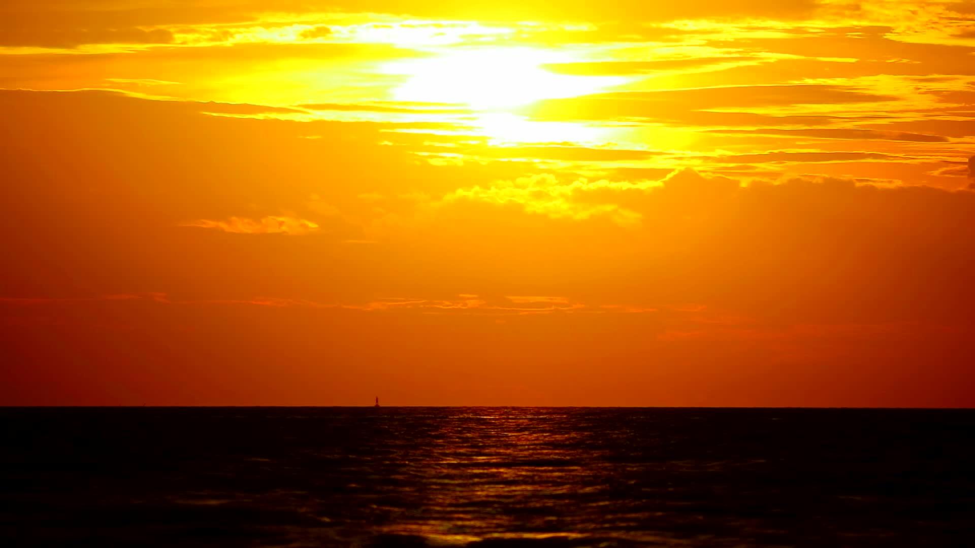 黄色、橙色、黄色的天空和红色的云在海上飘扬视频的预览图