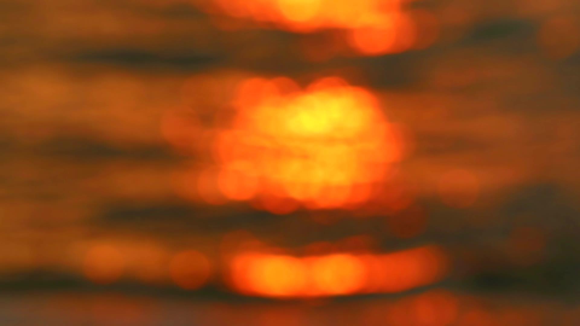 日落的红色和黄色反射了海水的抽象表面模糊多彩视频的预览图