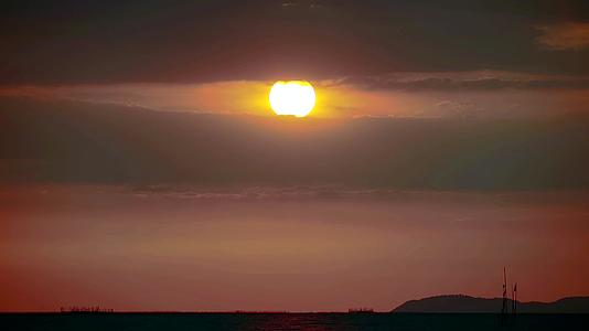 日落的天空又回到了海上渔船的云层时间流逝视频的预览图