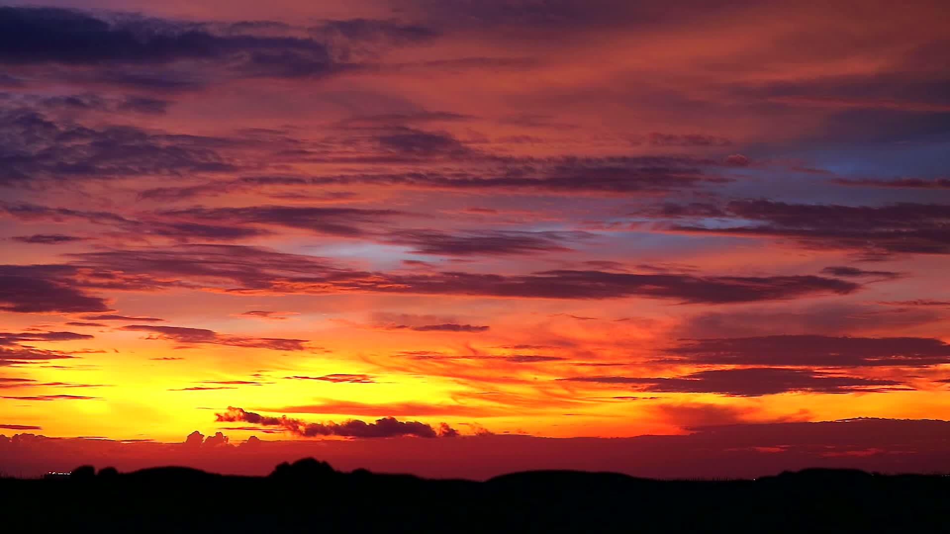 日落、橙色天空和暗红云在模糊的双周山1上飘动视频的预览图
