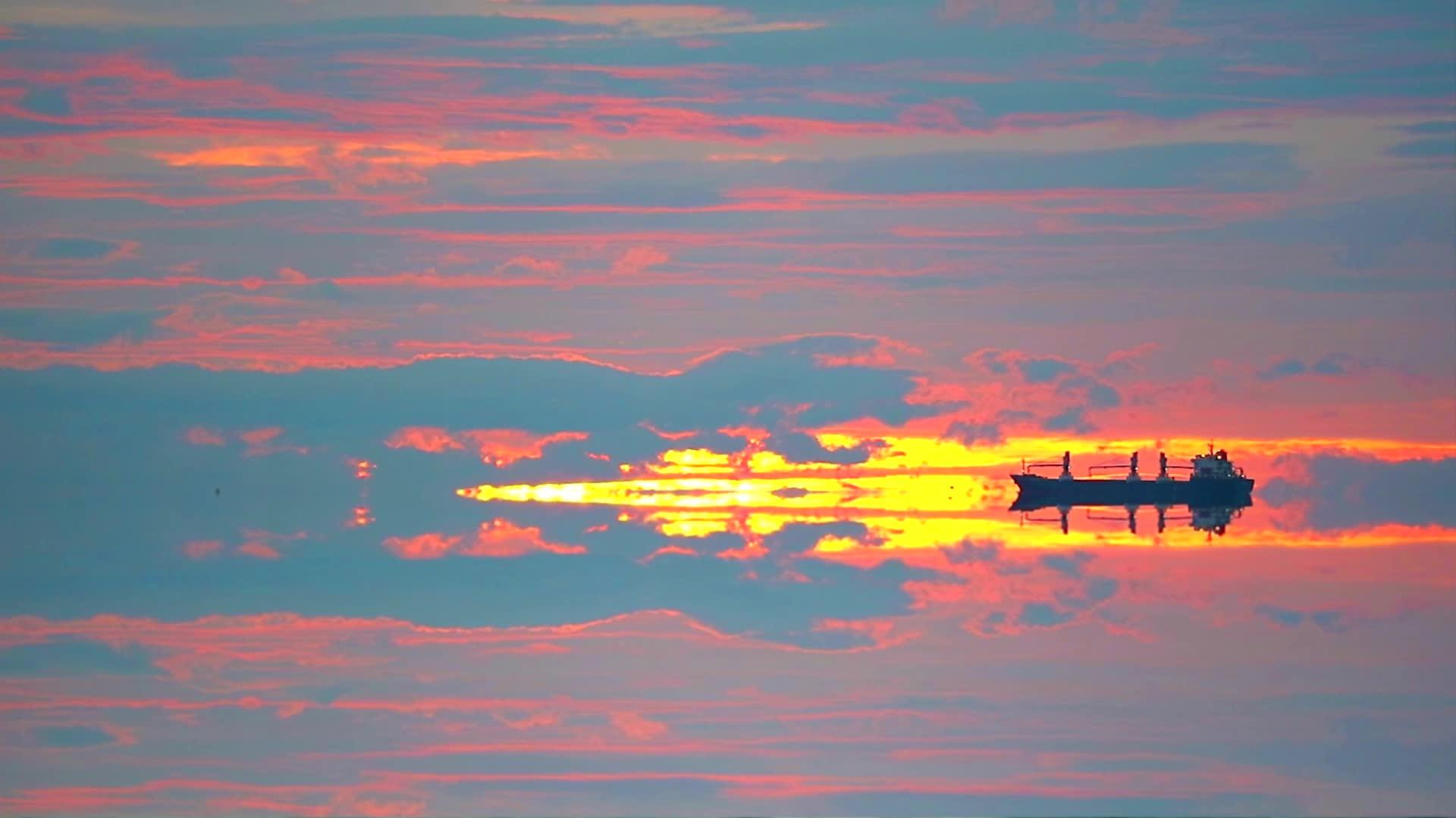 日落天空的海洋和云朵停靠反思货船视频的预览图