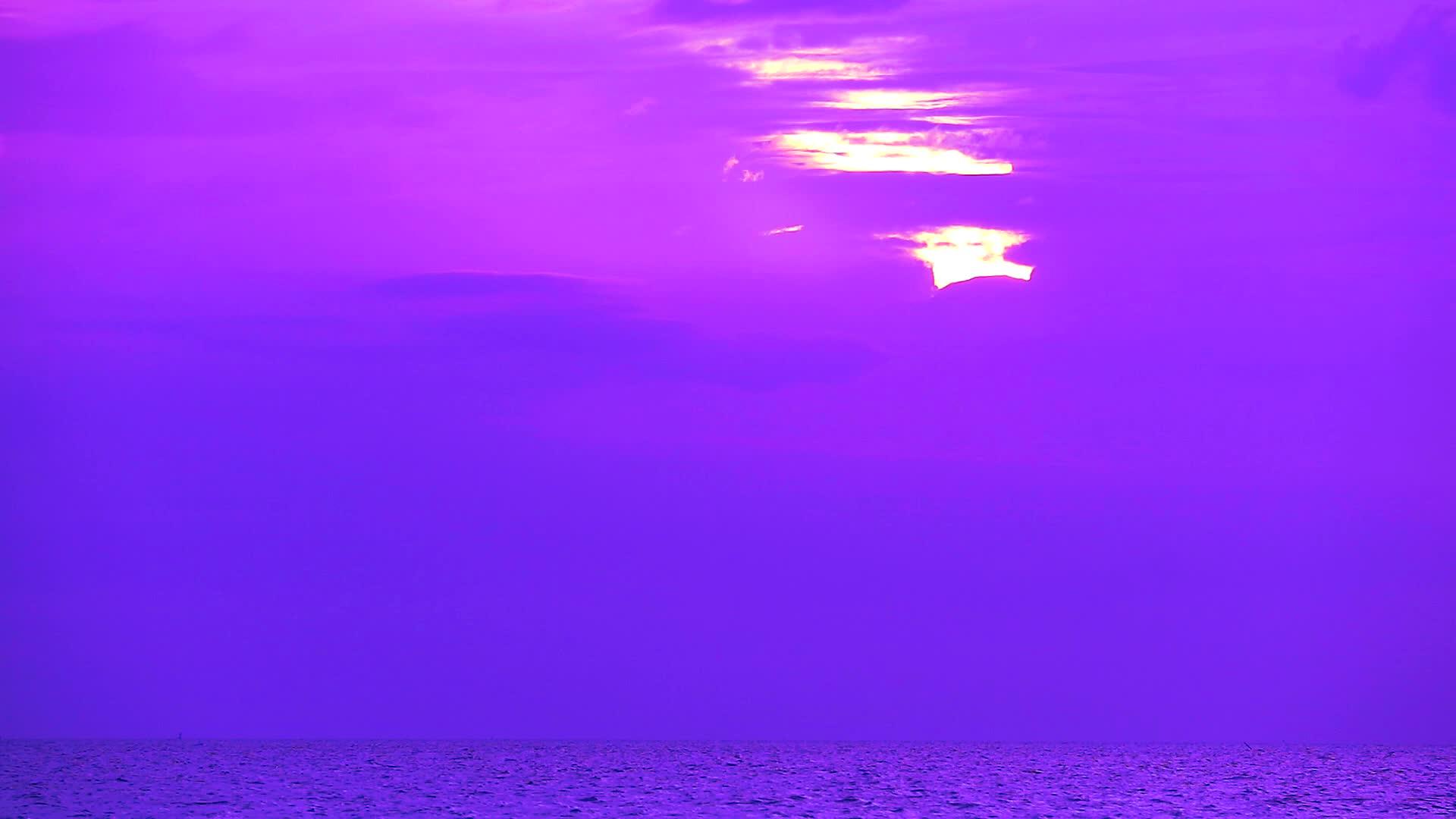 太阳照耀在海面上的紫云和橙色的天空上视频的预览图