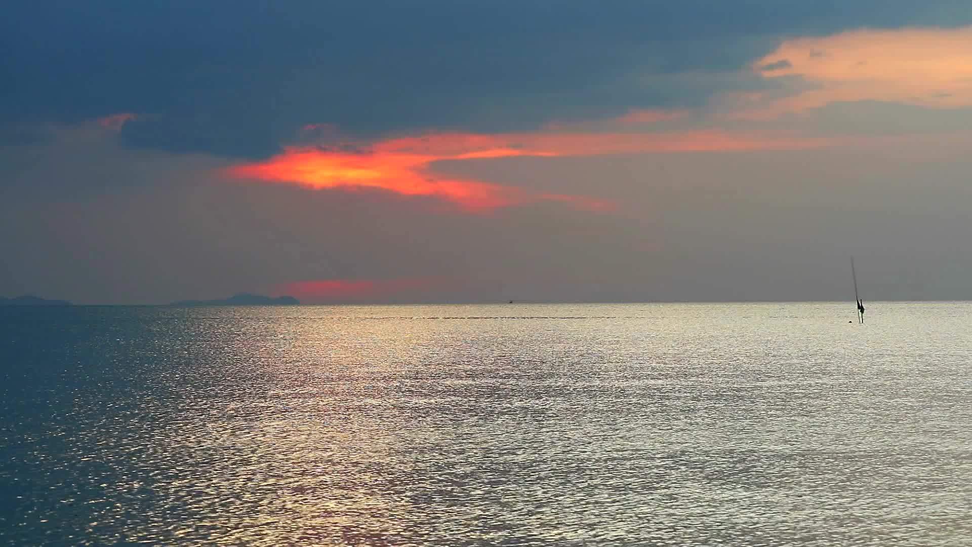 灰色的红色日落反射在水面和天空的水面上视频的预览图