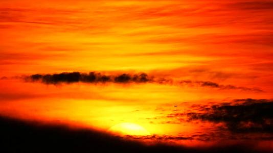 日落在黑暗的红云和橙色的天空中空中飞过太阳视频的预览图