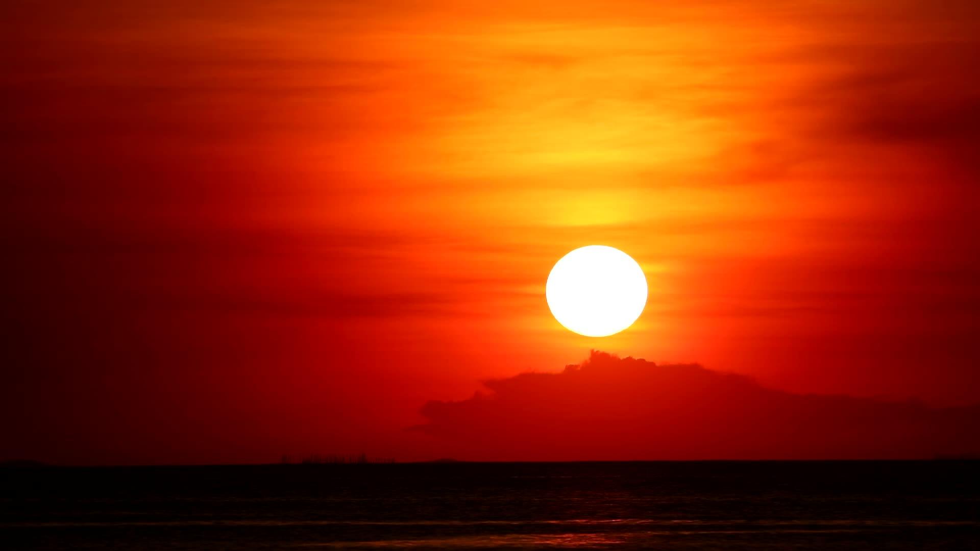 红色和橙色天空的日落回到浅橙色云和深海之间的时差视频的预览图