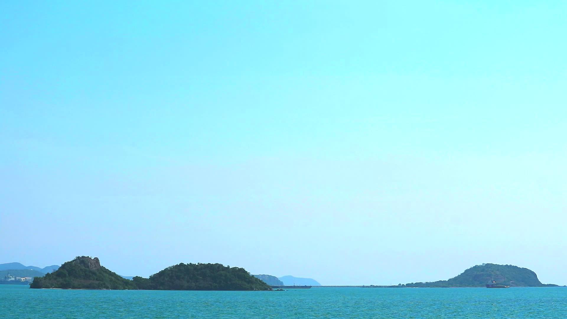 货船在远海和岛屿上以及清空天空的背景视频的预览图