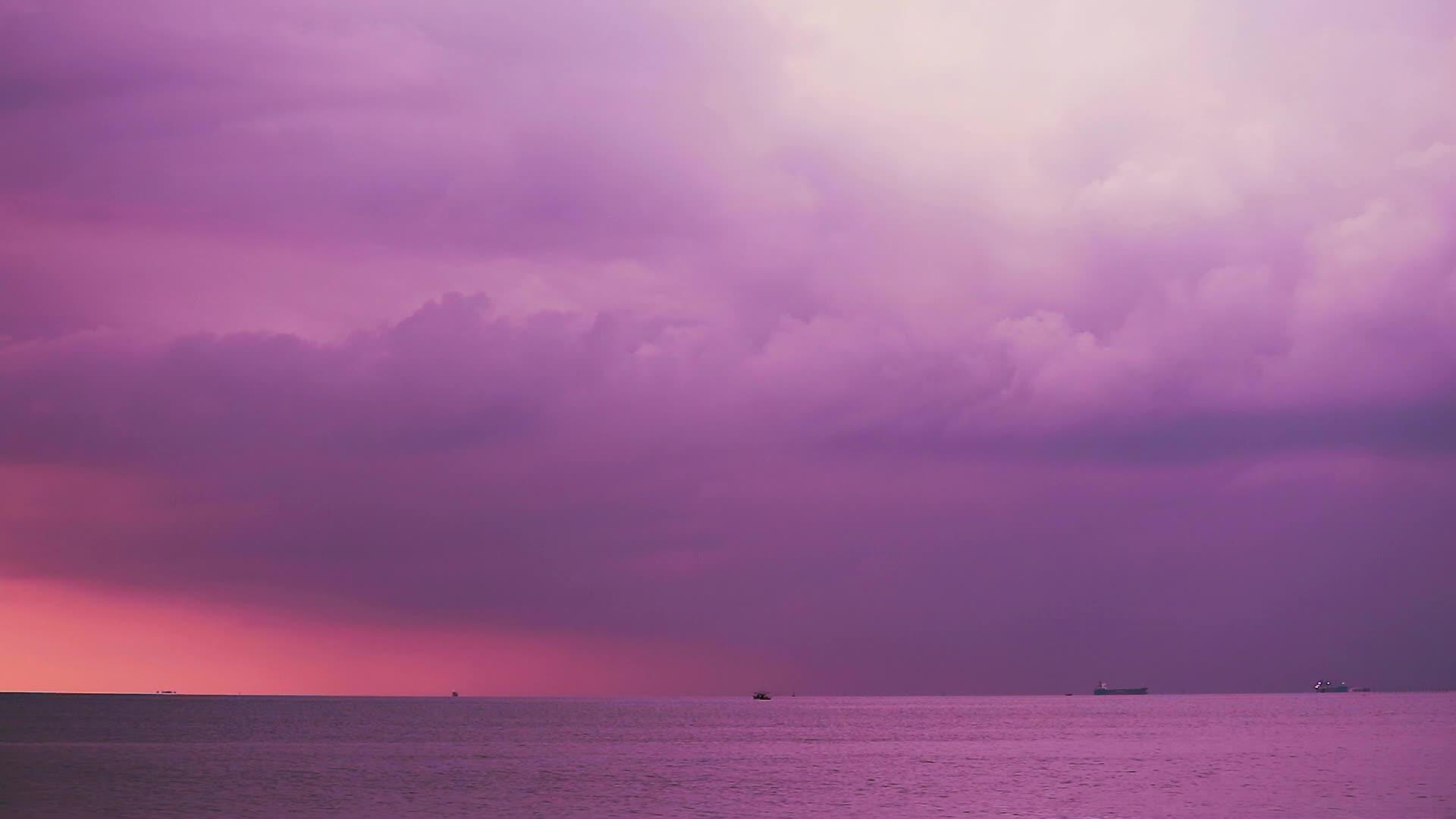 海边日落夏天有紫色的浅紫色暴雨云视频的预览图