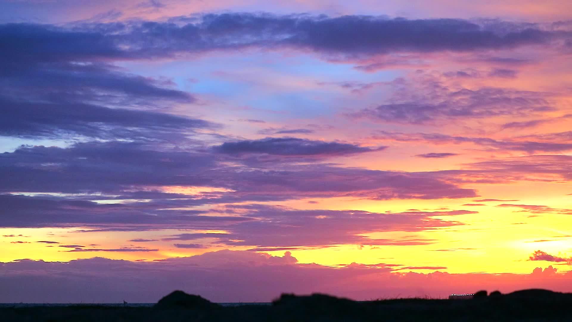 海滩上的日落和浅影沙沙冷蓝调天空上的热红色云视频的预览图