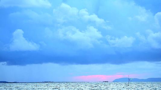 日落黑暗的天空红色的风暴云在海面上漂浮在光明的货船和水面上视频的预览图