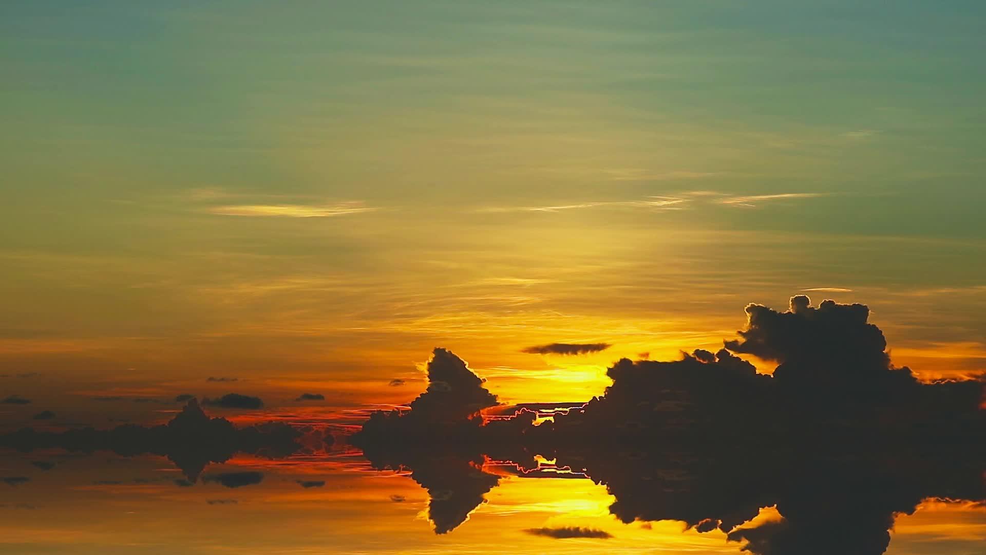日落和彩虹反射着五颜六色的天空和暗云在水面上移动视频的预览图