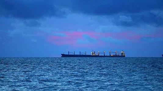 日落黑暗的天空红色的风暴雨云在海上漂浮双轮货船和水上波浪视频的预览图