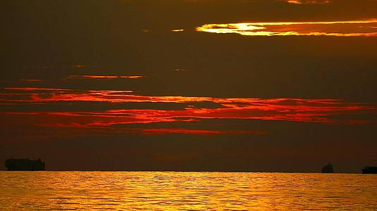日落和反射阳光照射在海面上的黑暗天空和表面的小波浪上视频的预览图