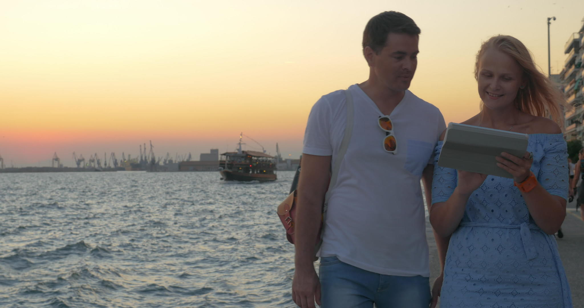 日落的年轻夫妇在海边散步...塞萨洛尼基视频的预览图