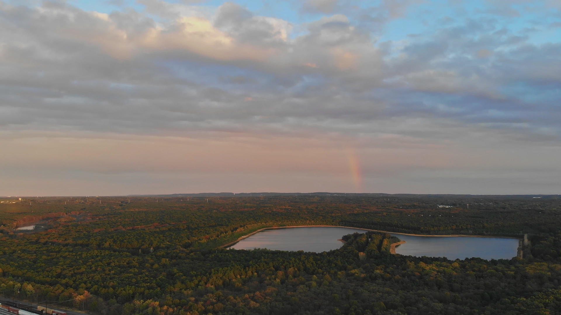 日落时无人驾驶飞机和森林在湖面上飞行视频的预览图