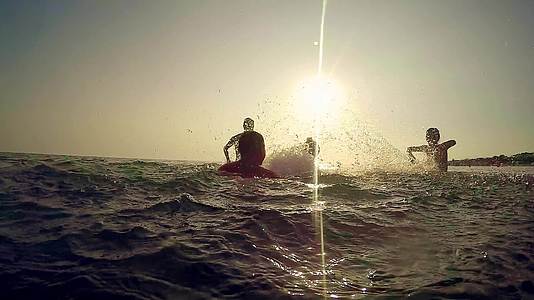 快乐的家庭在海洋中玩耍日落时溅水的剪影——热带游客视频的预览图