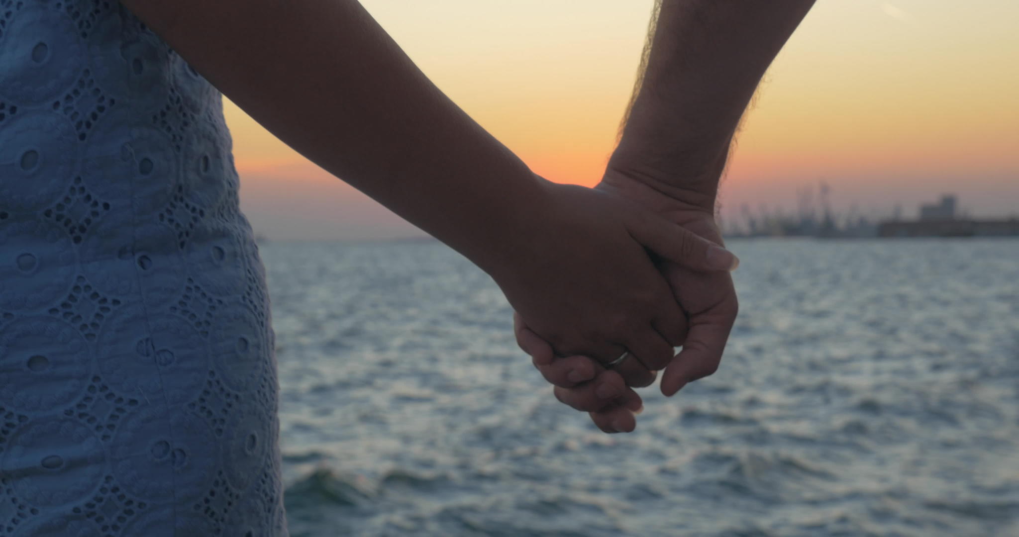 一对浪漫的夫妇在海滩上牵手视频的预览图