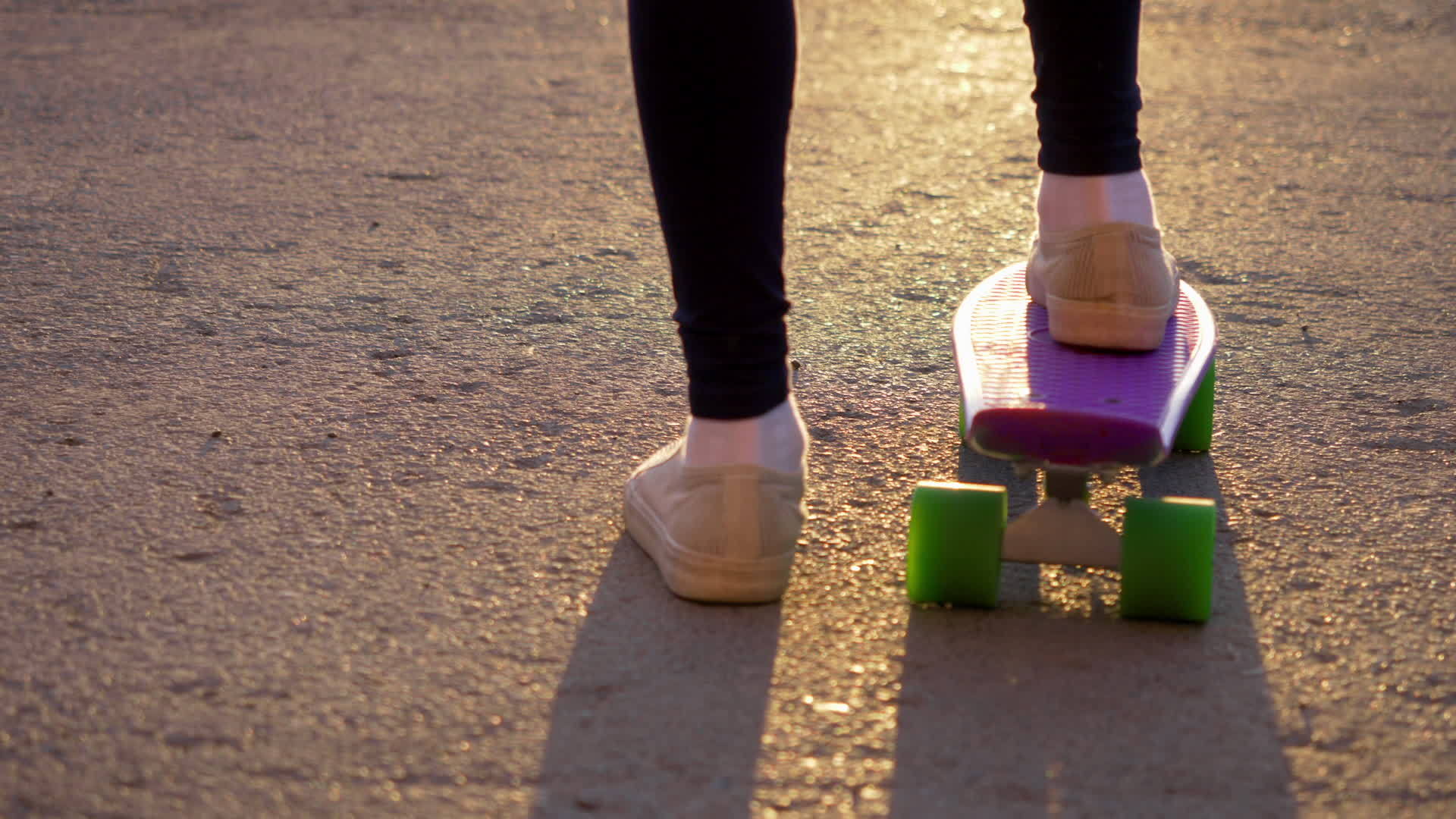 一个穿着白色运动鞋的女孩骑着滑板在沥青路上推着自己Slomo视频的预览图