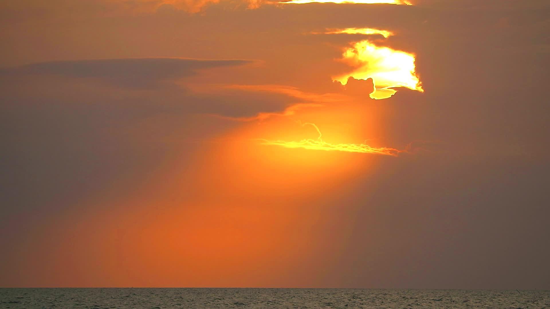 日落和阳光照耀着海边的云和橙色的天空视频的预览图