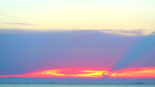日落和火焰云照耀着海面天线上的小岛货船视频的预览图
