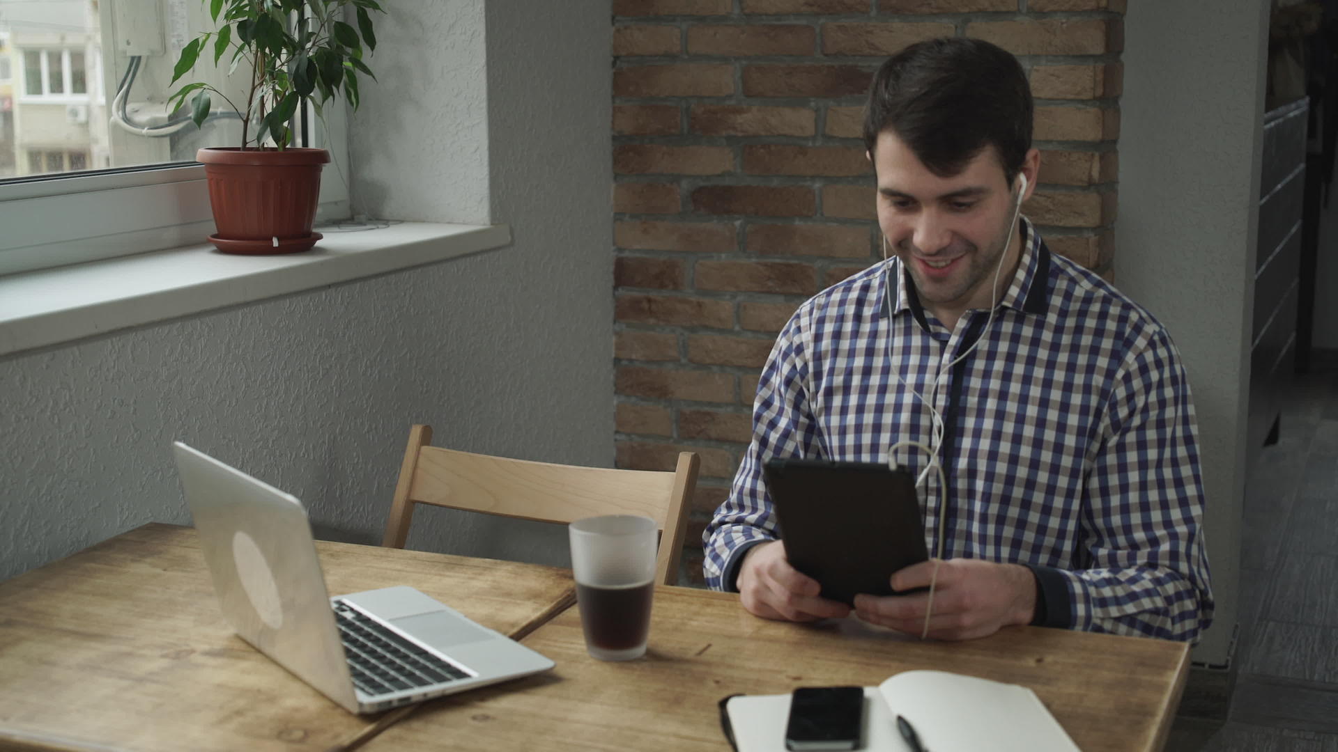 早上男人们坐在咖啡馆里喝着咖啡在平板电脑上聊天视频的预览图