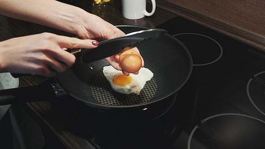 女人用刀把鸡蛋打碎在锅上煎视频的预览图