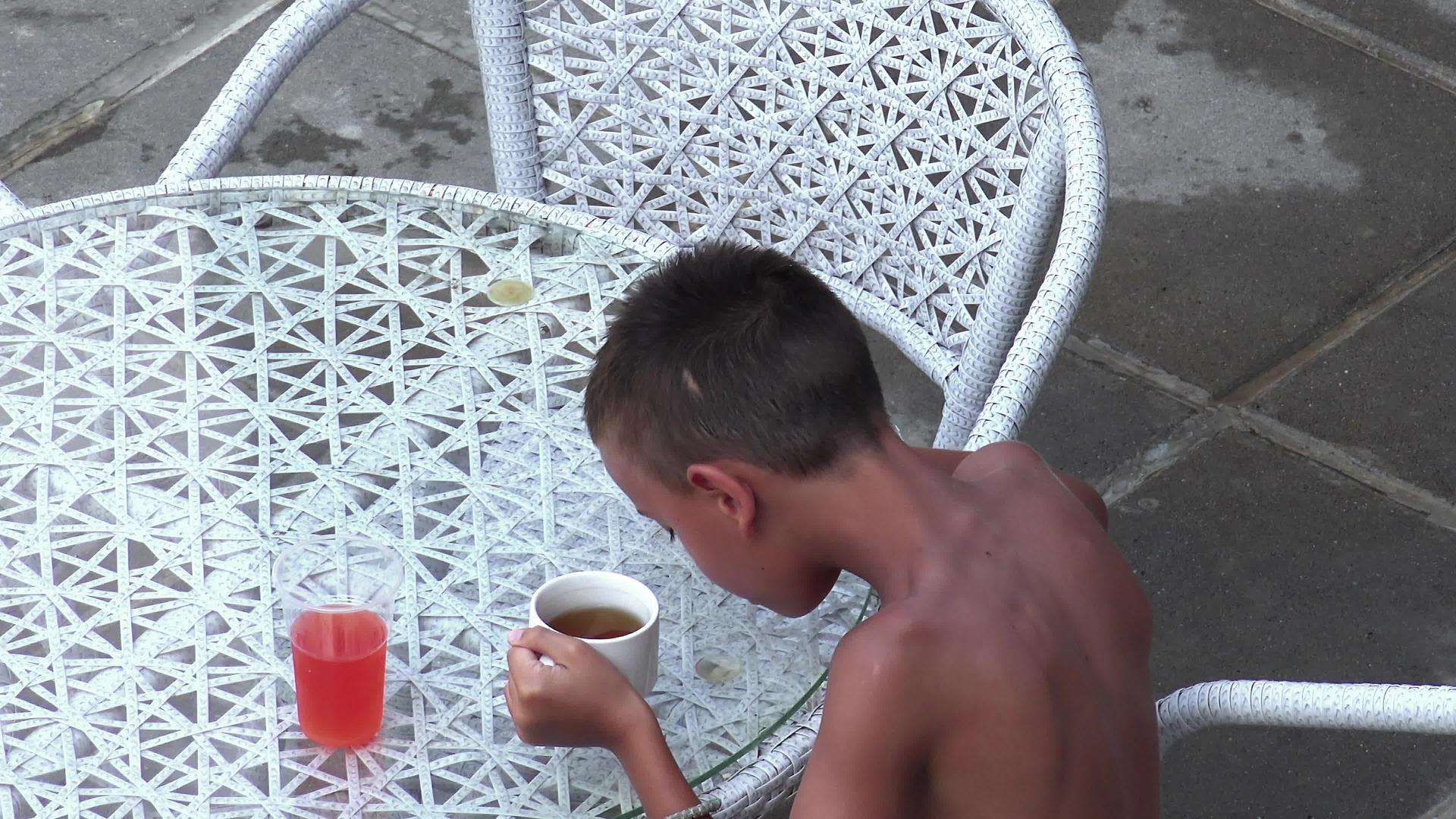 可爱的小可爱男孩坐在餐桌旁喝着果汁和茶做早餐过着健康的生活视频的预览图