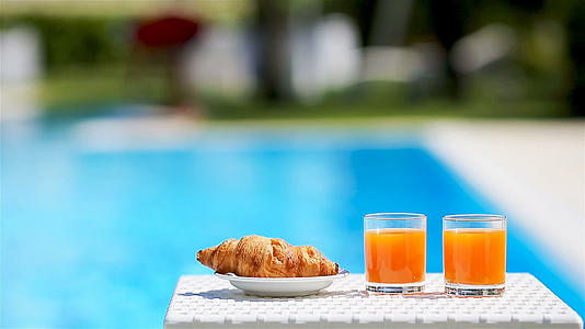 美味的早餐柠檬咖啡羊角面包在游泳池旁边视频的预览图
