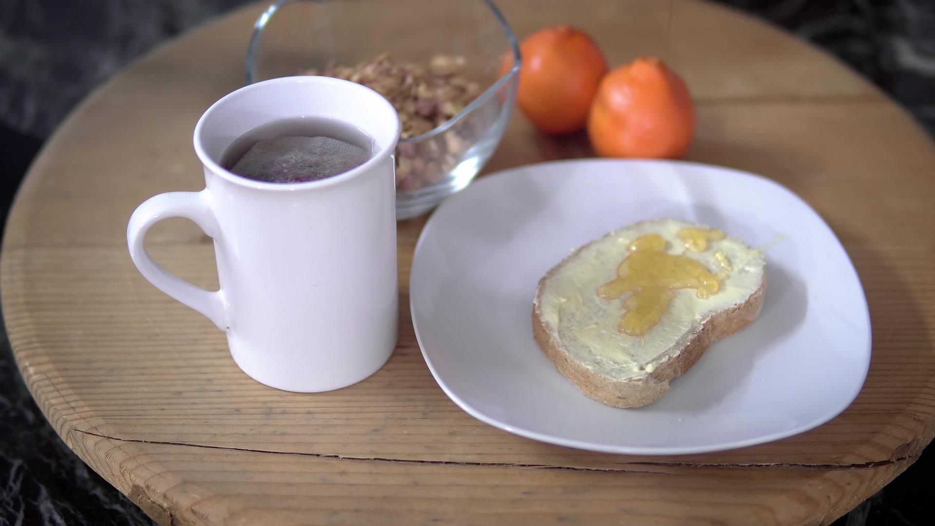 早餐时间餐桌在面包面包上散布蜂蜜在木板上散发黄油和黄油视频的预览图