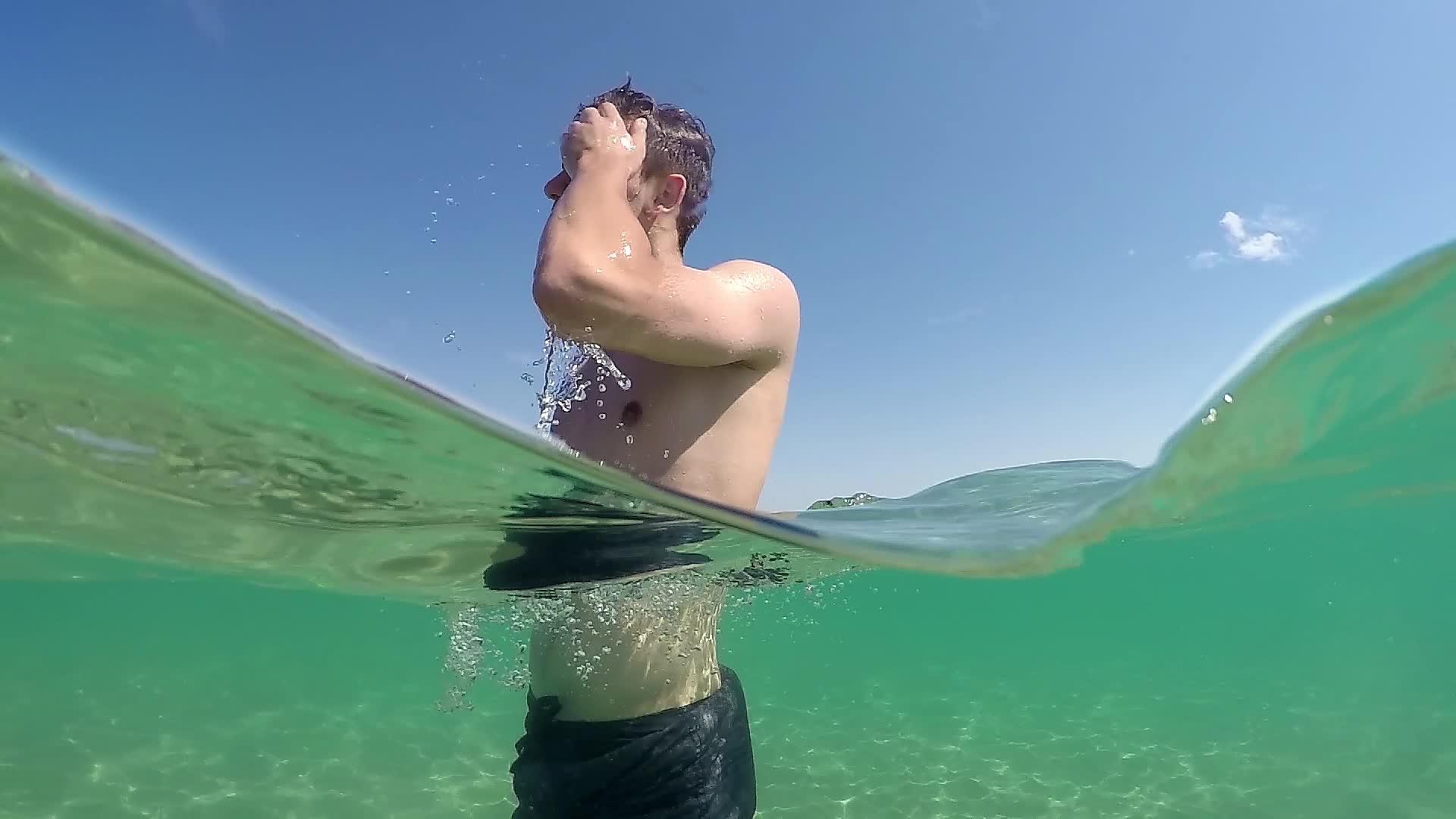 时尚男模男青少年做他的发型暑假期间在海水中微笑视频的预览图