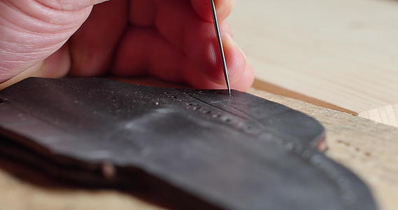 皮革工匠在手工制品中手工制作和缝制皮革制品视频的预览图
