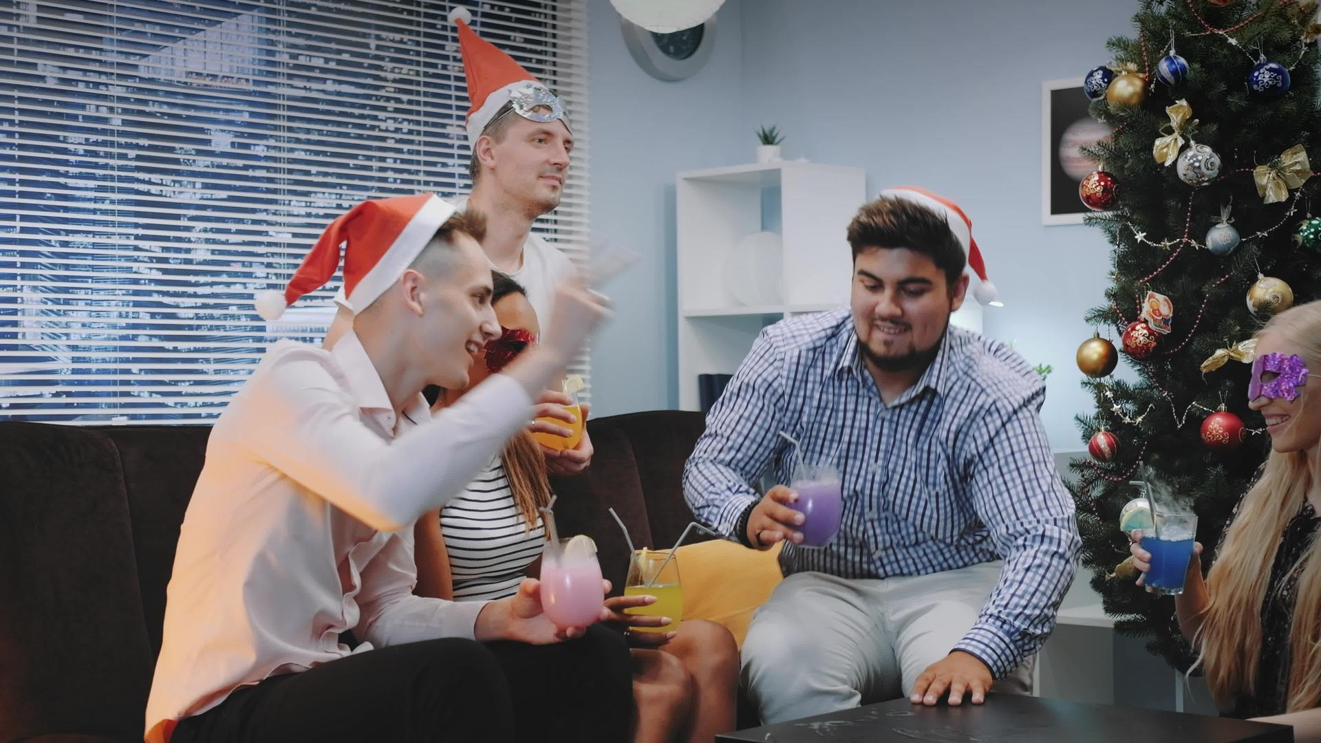 戴着圣塔帽和派对面具的跨国青年在圣诞节欢呼视频的预览图