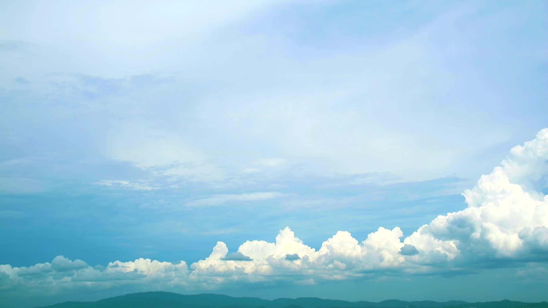 蓝天纯白云在雨季穿过绿色山顶视频的预览图