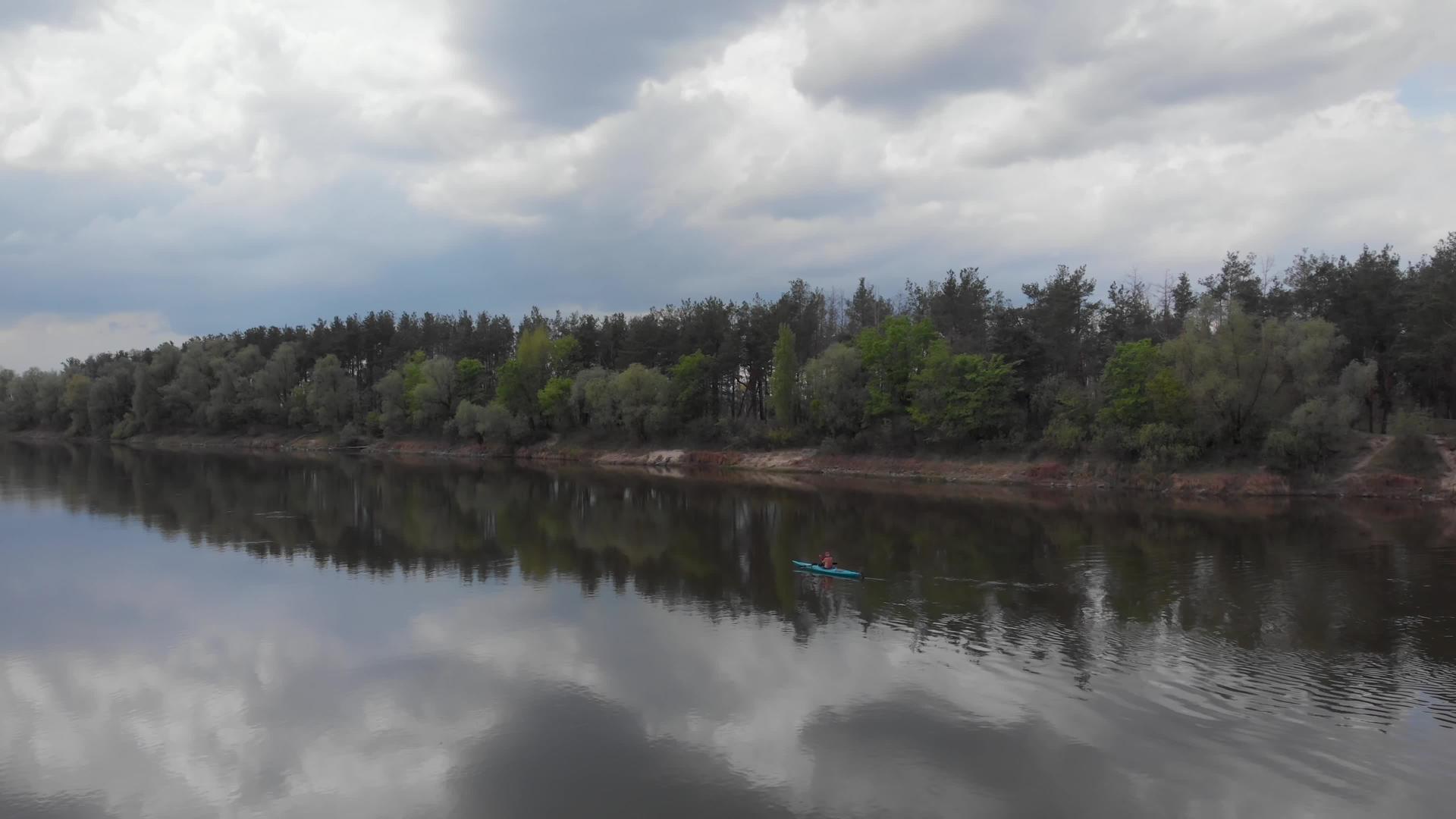 春天在德斯纳河下游的宽阔平静的水筏河床上乘坐蓝色皮划艇视频的预览图
