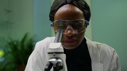 非洲研究人员的女性在显微镜下观察树叶近距离观察视频的预览图