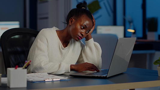 在笔记本电脑工作之前疲惫的非洲自由职业者在手头休息视频的预览图