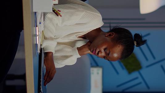 女性坐在工作场所时按摩头部；在非洲工作过多的工作场所工作视频的预览图