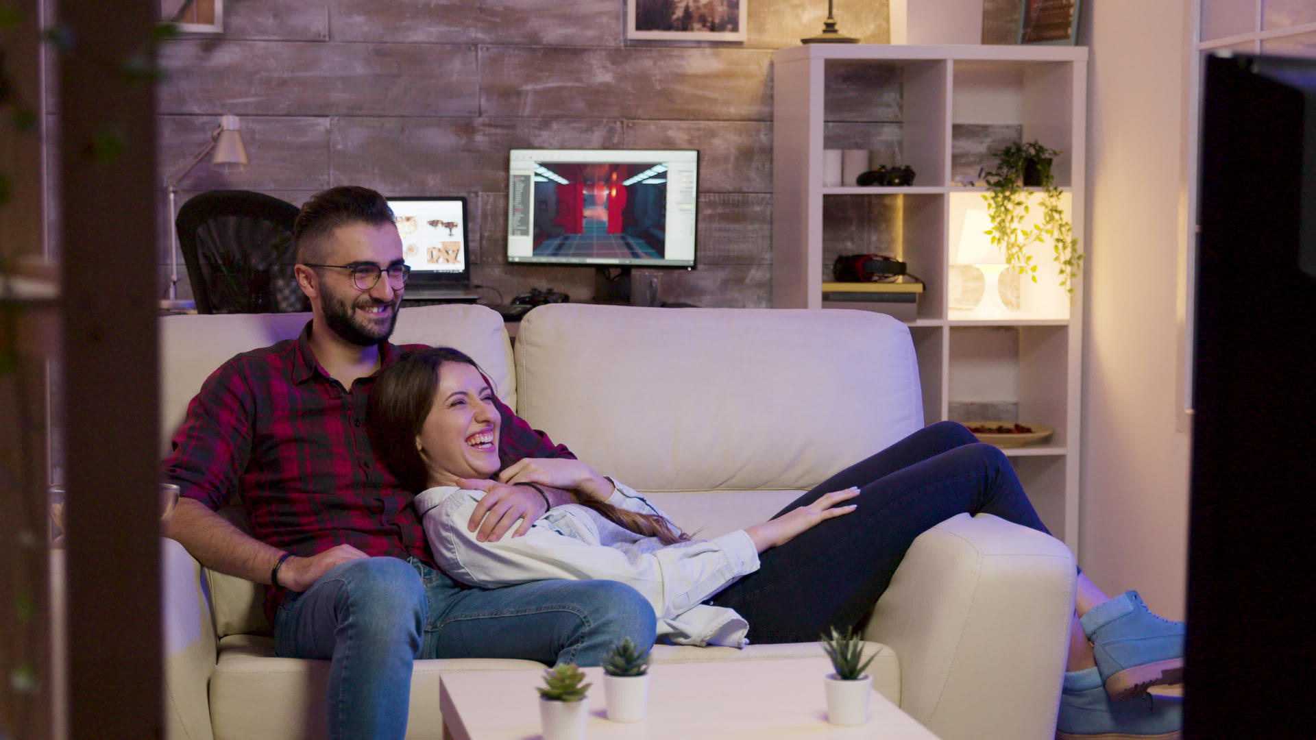 一对迷人的夫妇躺在沙发上看电影视频的预览图