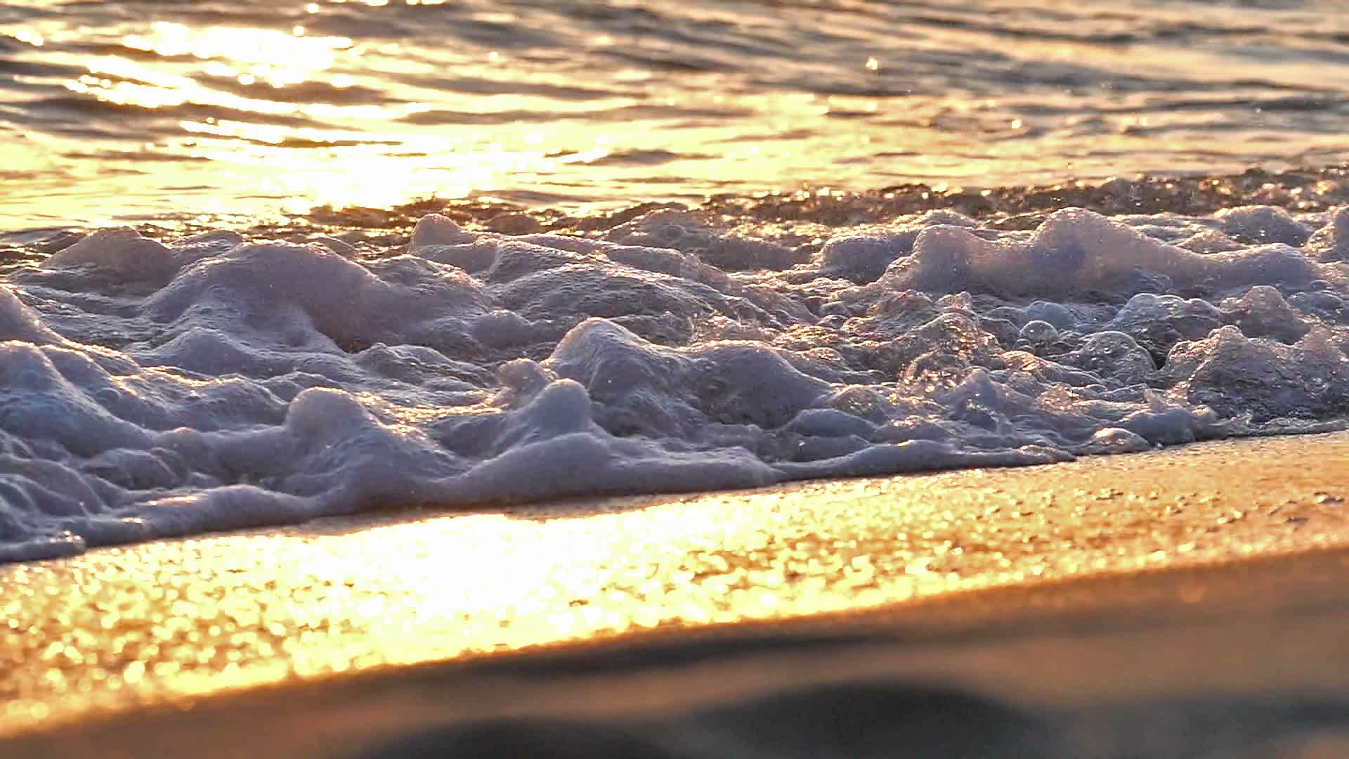 当日落缓慢时海滩上的海浪喷洒视频的预览图