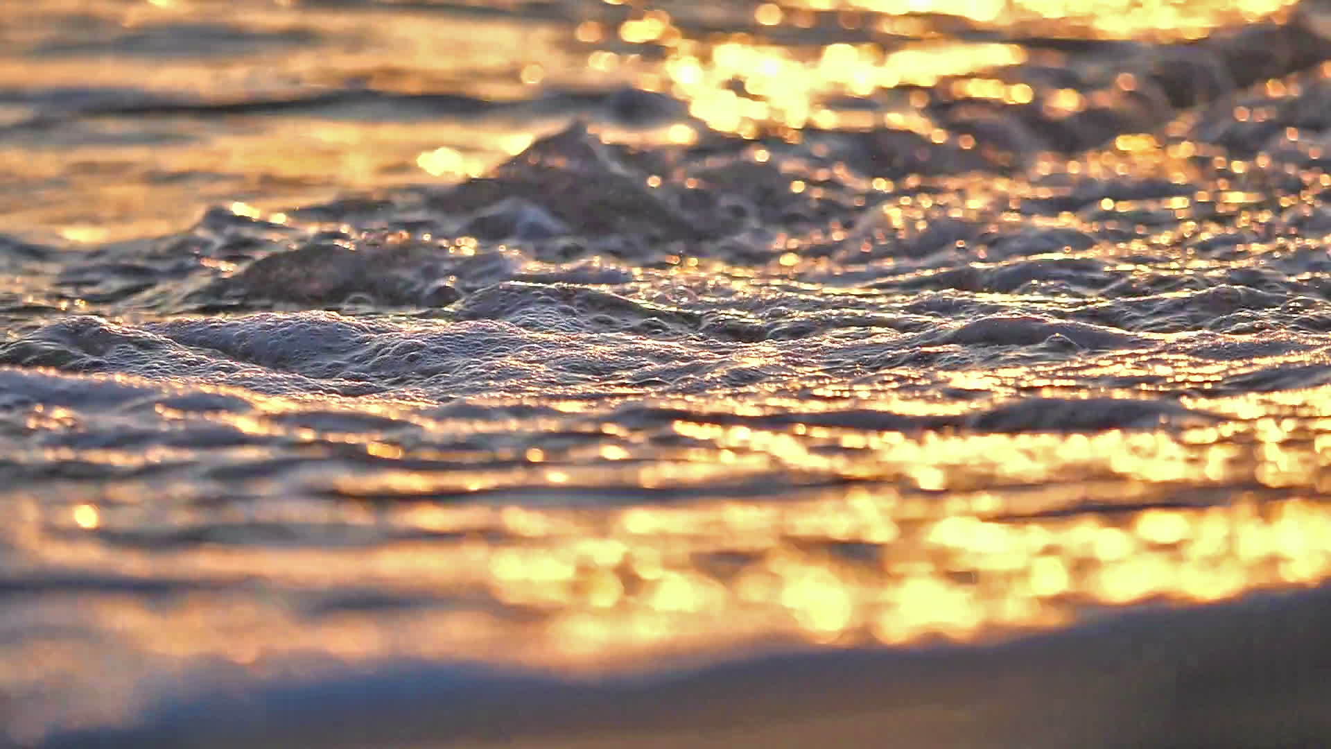 当日落缓慢时 海滩上的海浪喷洒视频的预览图