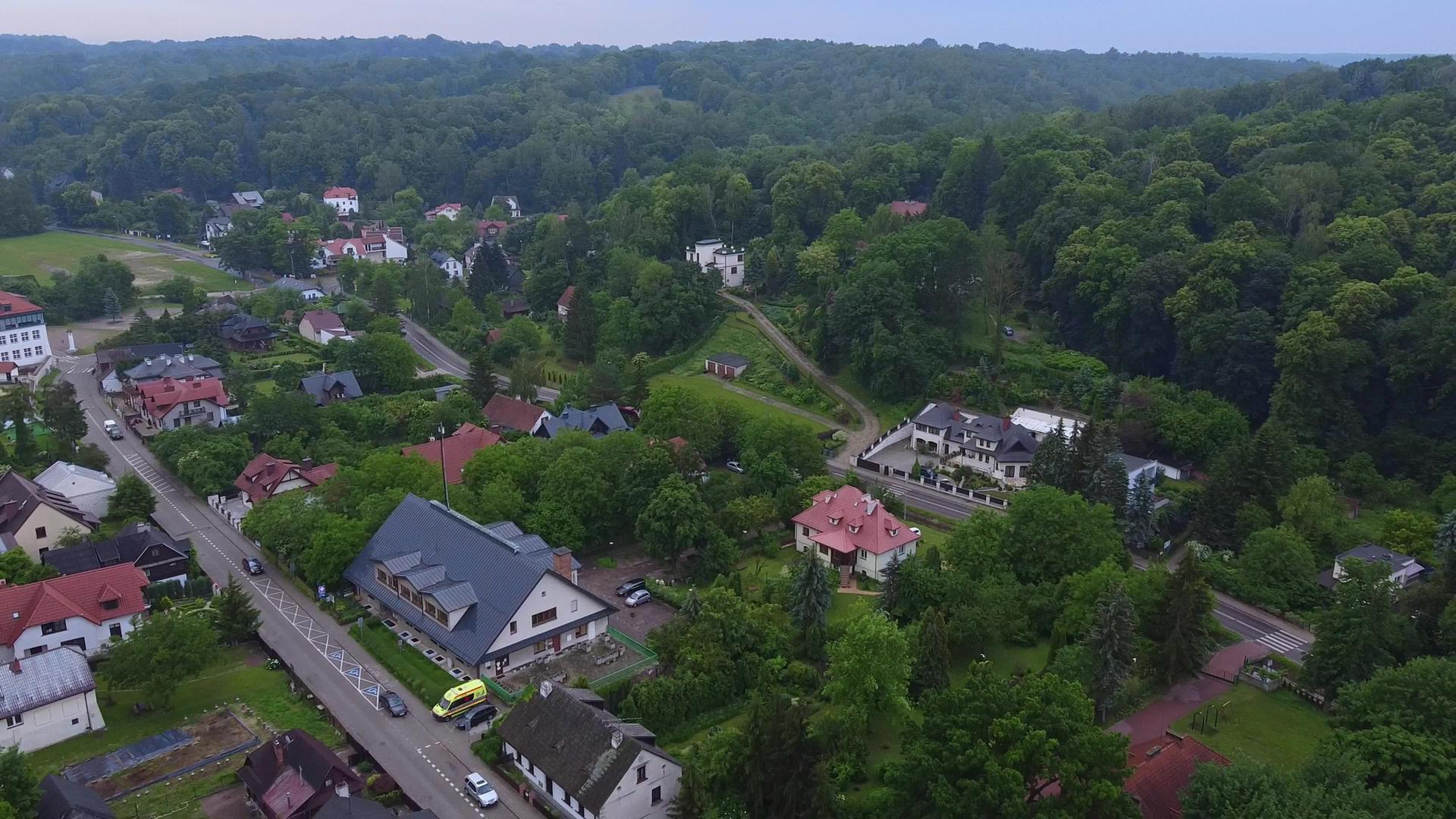 城市建筑和绿色森林的空中飞行视频视频的预览图