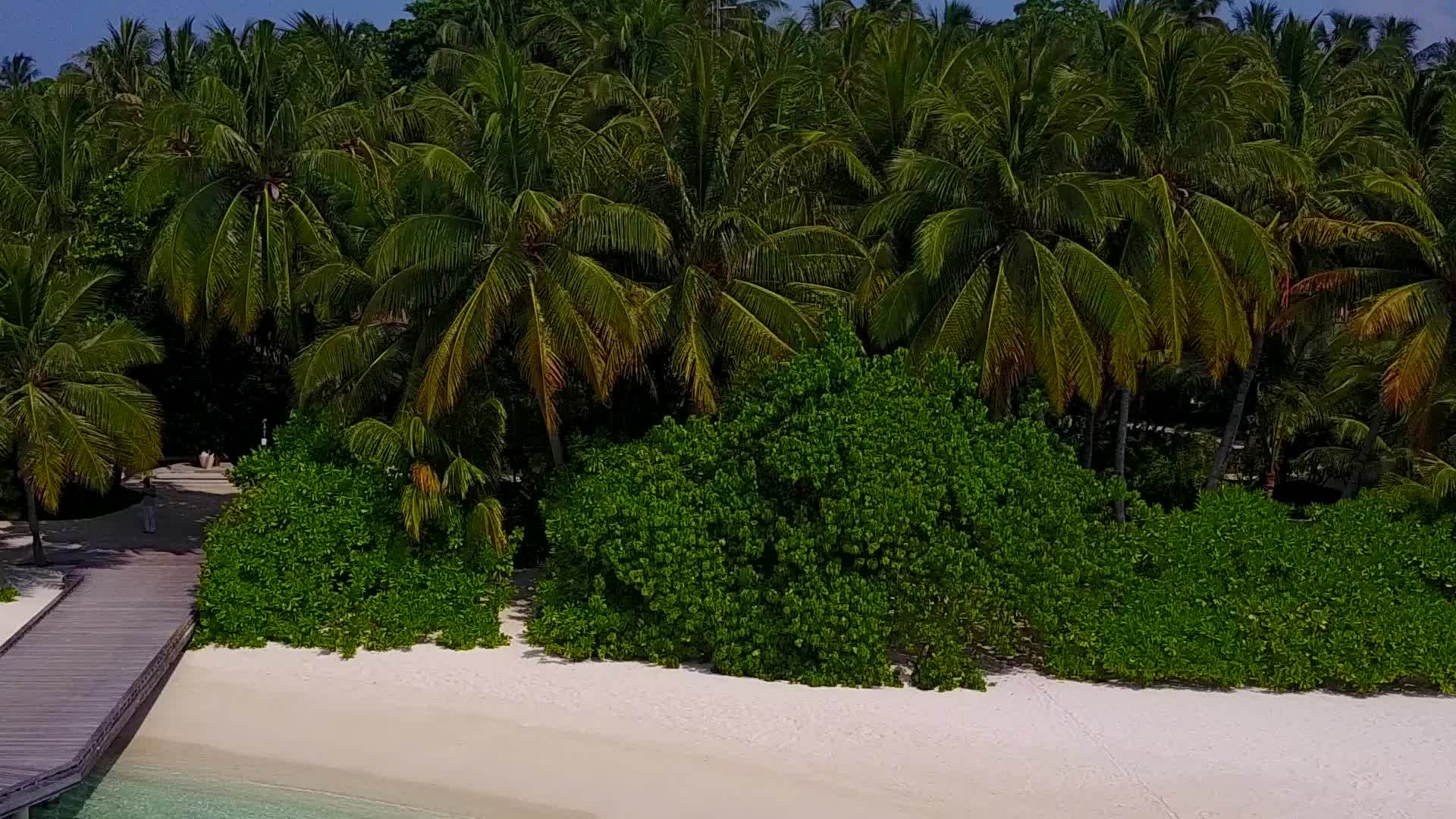 阳光明媚的美丽海滩穿过浅海珊瑚礁附近的白色沙滩视频的预览图