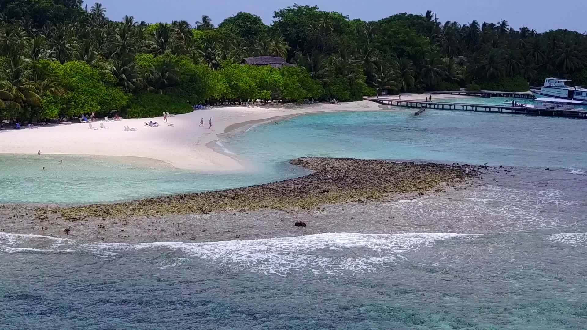 在珊瑚礁附近有白色沙沙背景的蓝色海洋中放松环礁湖海滩休息一下视频的预览图