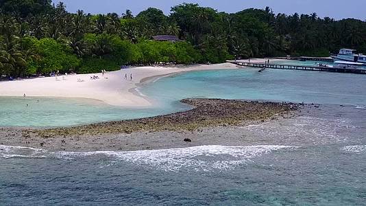 在珊瑚礁附近有白色沙沙背景的蓝色海洋中放松环礁湖海滩休息一下视频的预览图