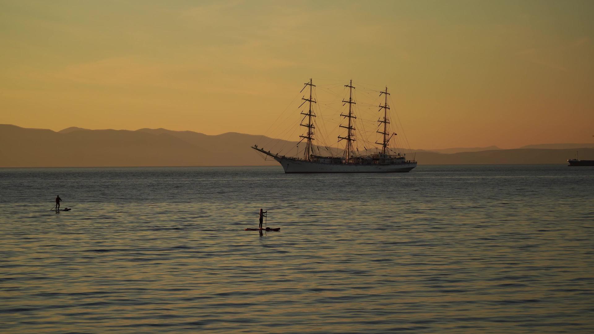 海景包括帆船和日落板上的人视频的预览图