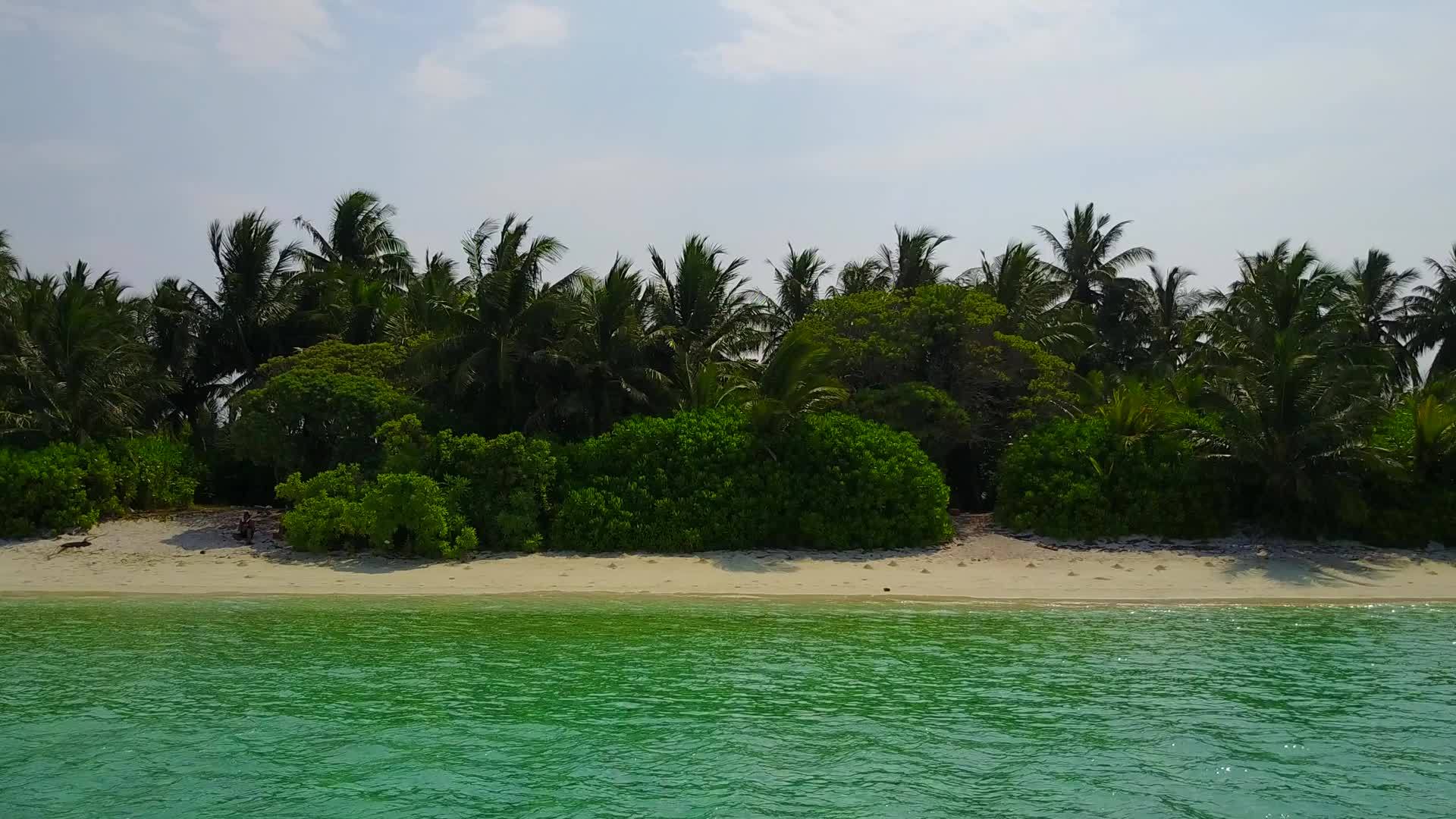 蓝绿色环礁湖和阳光下的白色海滩打破了热带岛屿海滩视频的预览图
