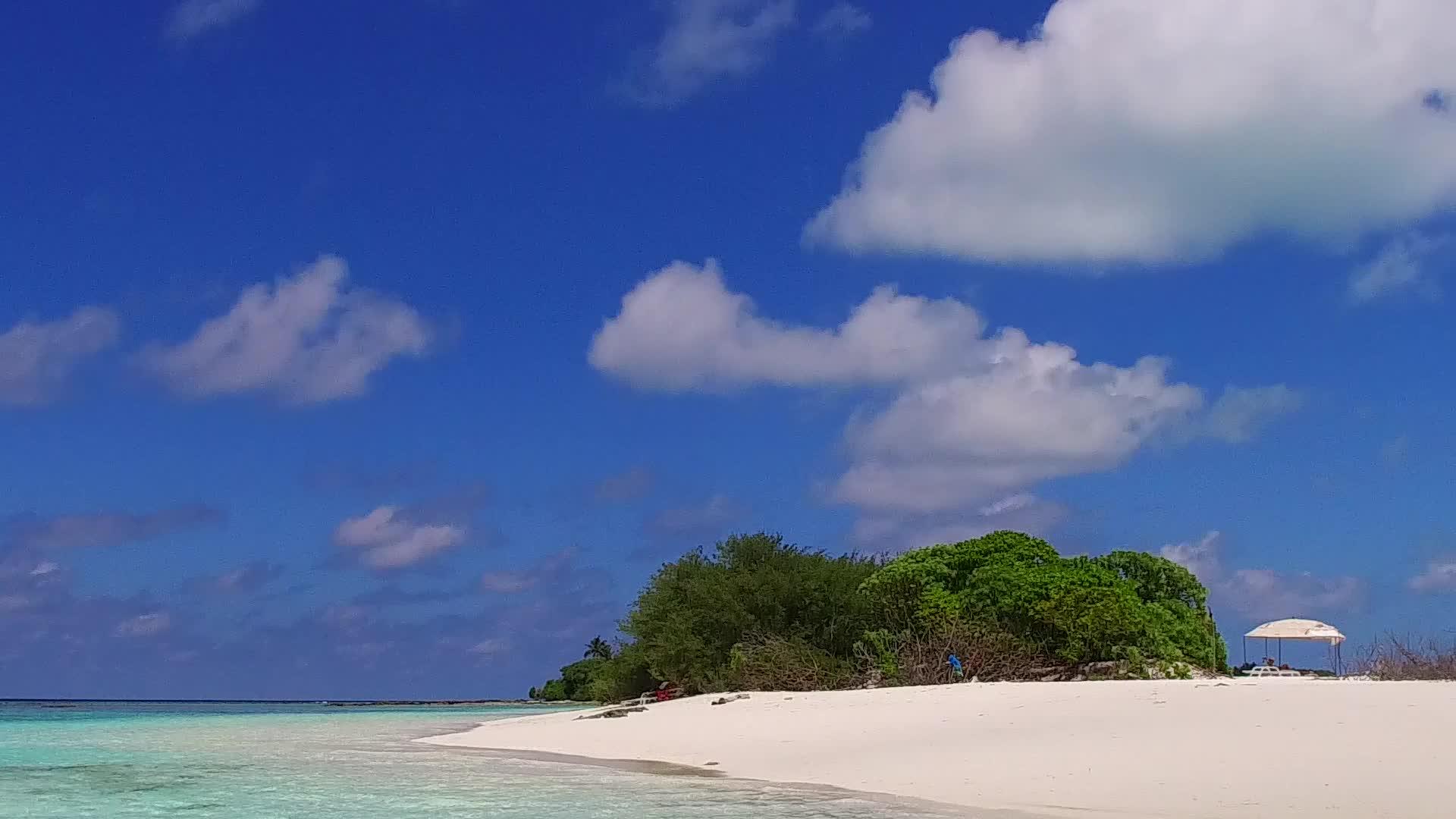 棕榈树附近的蓝绿色环礁湖和白色沙底背景下阳光明媚的海滩度假胜地视频的预览图